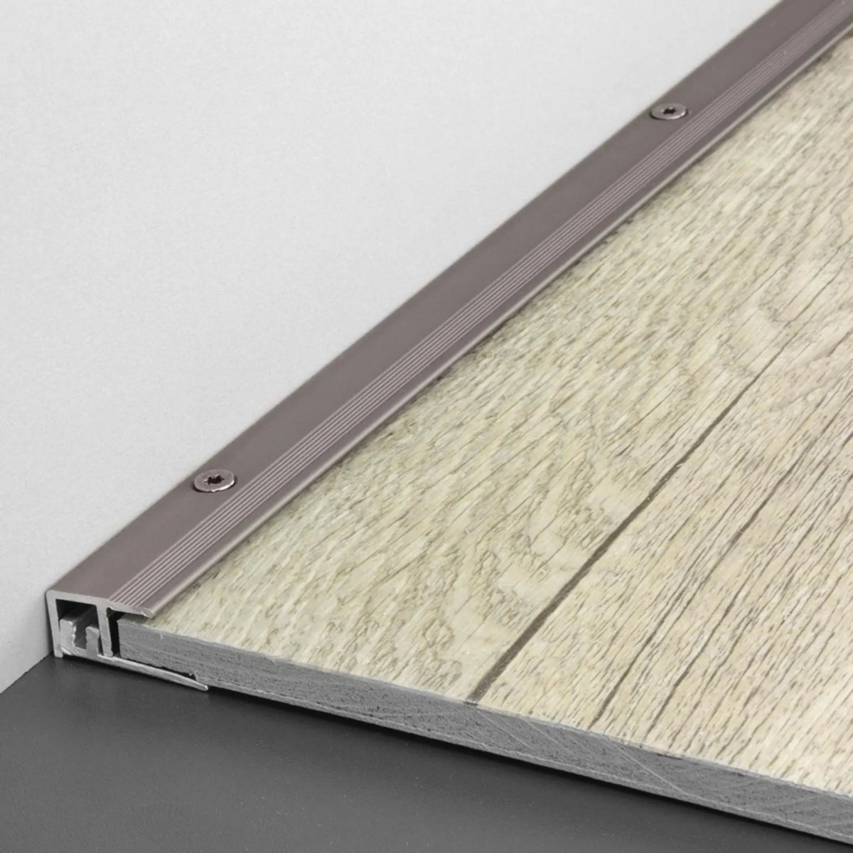 DURAL Abschlussprofil DUOFLOOR LVT titan mit sichtbaren Schrauben vor einer Holzfliese verarbeitet