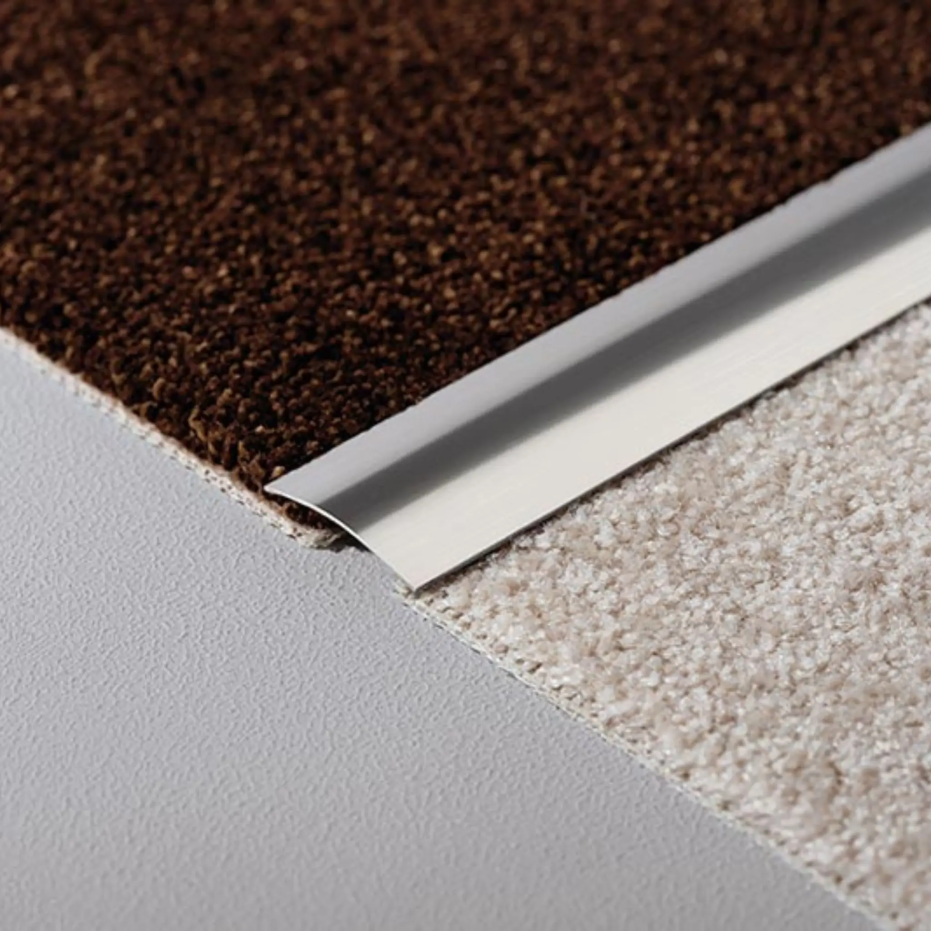 Ambientebild Übergangsprofil aus Edelstahl leicht gewölbt zwischen zwei Teppichen