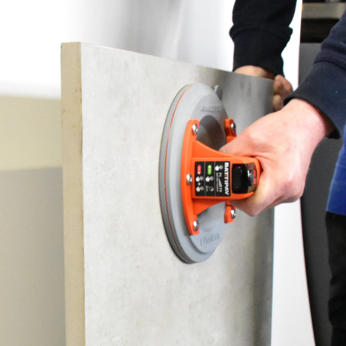 Ambientebild Person hebt mit dem Saugheber Battipav eine Fliese schräg an